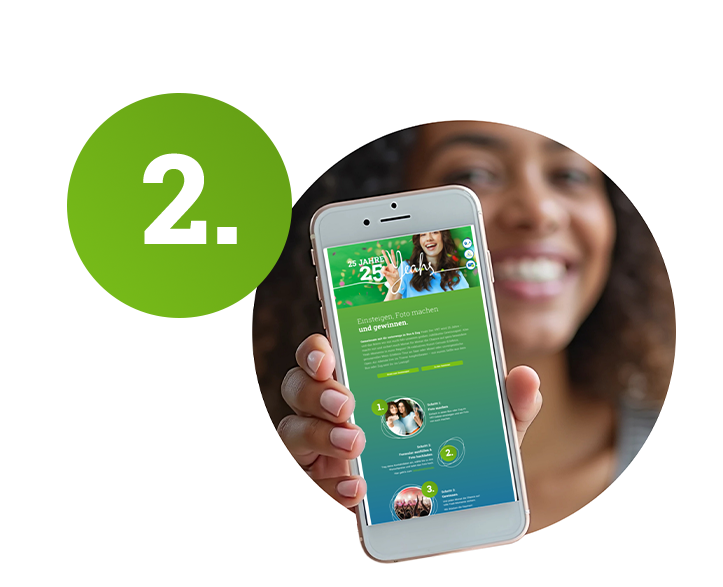 Eine Frau zeigt ein Handy mit einer Website darauf.